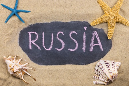 Handwritten word RUSSIA written in chalk, among seashells and starfishes. Top viewの写真素材