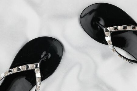 Sandals, flip flops, inlaid with rhinestones, standing on white fabric. With space for design, text place. Top view.の写真素材