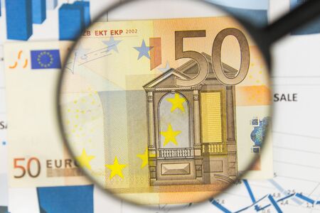 Close-up of fifty euros through a magnifying glass. Business background. Money research concept. Top...