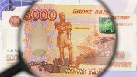 Close-up of five thousand rubles through a magnifying glass. Business background. Money research...
