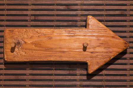 Wooden pointer made of wood with a wooden gag lie on a bamboo mat. Top view. Hard light for hard shadows. Copy spaceの写真素材