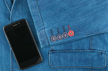 Phone lying on a denim suit. Fashion background. Top viewの写真素材