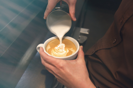 Cup of coffee. Latte art made by barista focus in milk and coffee. Vintage colorの写真素材