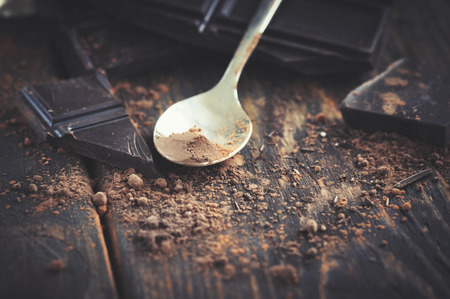 dark chocolate over wooden backround with some cocoa powderの写真素材