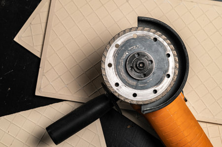 angle grinder machine and ceramic tile on black work tableの写真素材