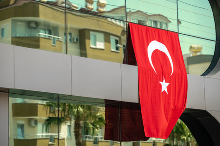 Turkish national flag on the facade glass building windows in a beautiful summer dayの写真素材