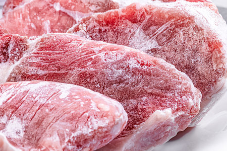 Raw frozen meat pieces. raw pork chops close-upの写真素材