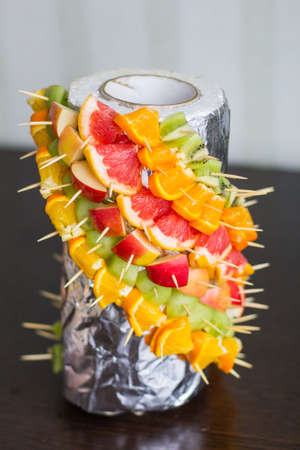 Fruit set fastened on toothpicks in foilの写真素材