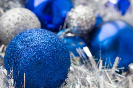 Christmas balls of different colors, blue, white in tinsel close-up.の写真素材