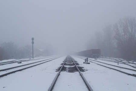 a railway track is shown on a day with heavy fog.