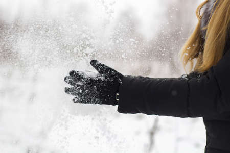 female black gloves with snow close up.の写真素材