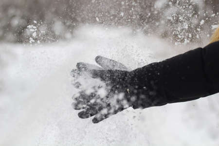 female black gloves with snow close up.の写真素材
