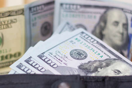 Dollar banknotes in leather wallet on white background.の写真素材