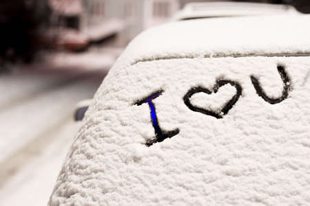 frozen car glass on a winter day with the words i love you.の写真素材