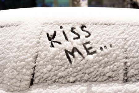 frozen car glass on a winter day with the inscription kiss me.の写真素材