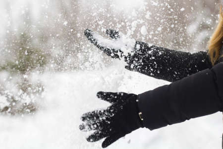 female black gloves with snow close up.の写真素材