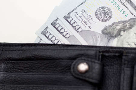 Dollar banknotes in leather wallet on white background.の写真素材