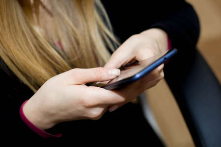 hand holding using mobile phone.girl using smart phoneの写真素材