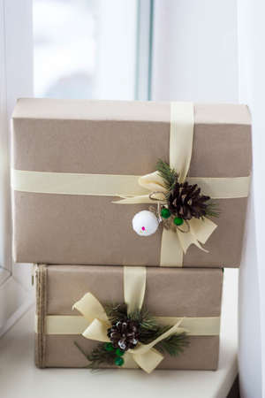 Gift box with ribbons decorations in the form of cones and branches of a Christmas tree close-up.の写真素材