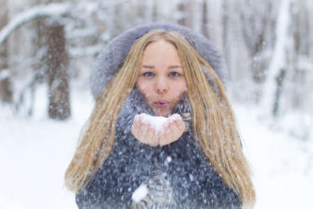 girl playing with snow in the forest closeup