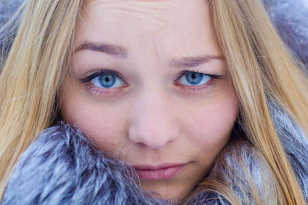 Portrait. Beautiful blonde girl smiling, weighs in winter weather.