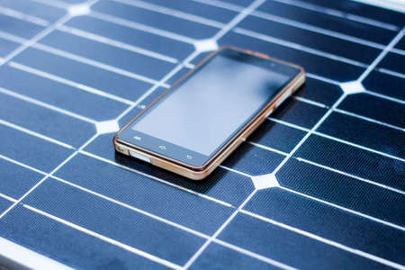 mobile phone on a solar panel outdoor close upの写真素材