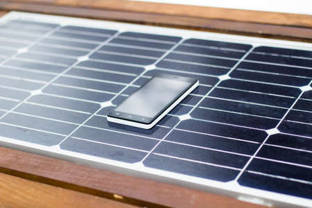 mobile phone on a solar panel outdoor close upの写真素材