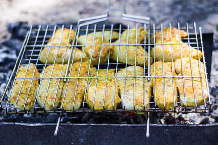 Cooking meat on the grill in the open air on the fireの写真素材