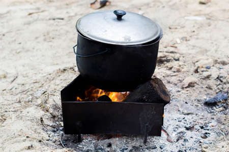 Cooking soup in a pot on the fireの写真素材