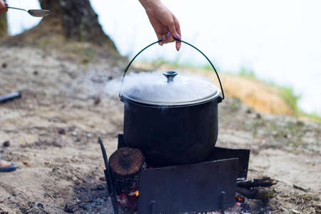 Cooking soup in a pot on the fireの写真素材