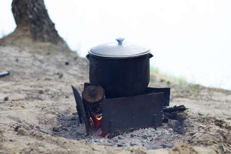 Cooking soup in a pot on the fireの写真素材