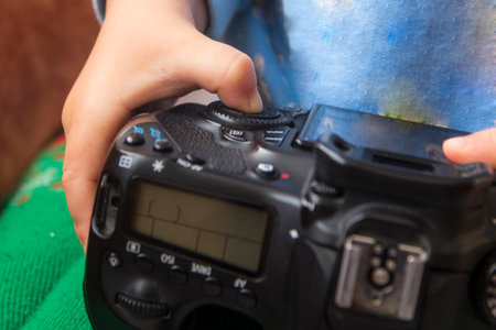 Toddlers hands hold a camera and press buttons close-up
