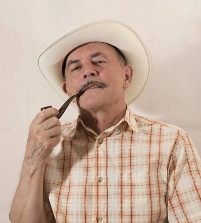 Cowboy in white hat with Pipeの写真素材