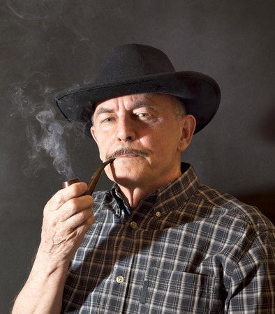 Cowboy in hat with Pipeの写真素材