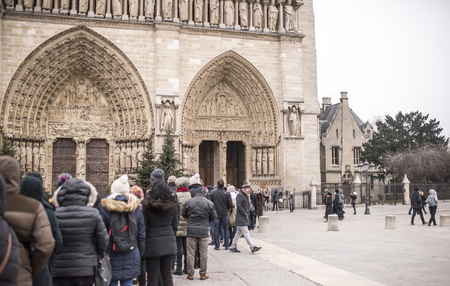 Paris, France- January 01,2017:Tourists stand in line at the Cathedral of Notre Dame, some walkingのeditorial素材