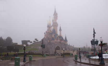 Paris, France- January 02,2017: Rare visitors walk into Disneyland Paris in heavy snowのeditorial素材