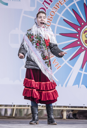 Rostov-on-Don,Russia - February 26, 2017: Maslenitsa-the girl in a national scarf sings at the festivalのeditorial素材