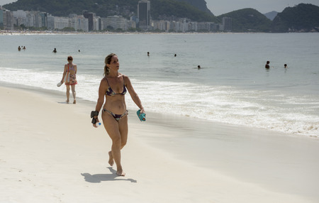 Rio de Janeiro, Brasil- March 05,2019: Pretty woman walking on the beach of Copacabana. Citizens bathe and sunbatheのeditorial素材