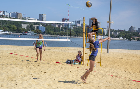 Rostov-on-Don, Russia - August 10, 2019 : Cute girls play beach volleyball. Friends watch the game.のeditorial素材