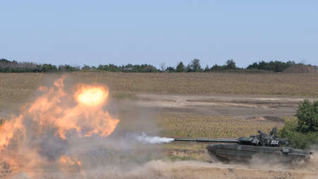 The tank fires a cannon and jumps from a springboard at the training groundの写真素材