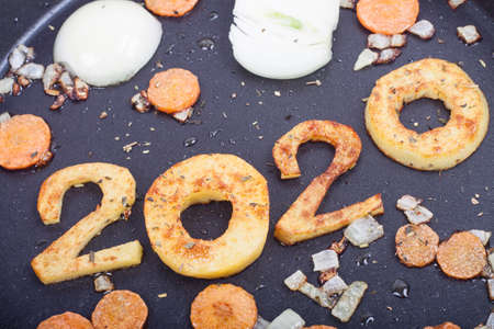 2020 number of new year laid out in a pan and fried with carrots and onions