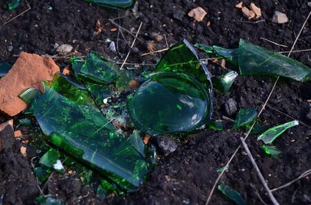 green bottle pieces and brick on the groundの写真素材