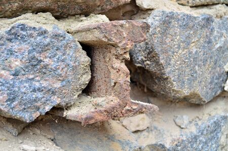Steel rail among granite stones