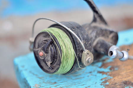 Photo of retro fishing reel on the wood