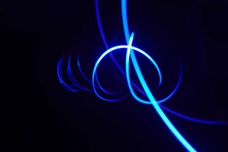 Curved bright blue lines of lightの写真素材