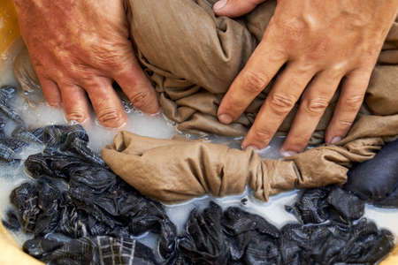 Photo of hand washing clothes in countrysideの写真素材