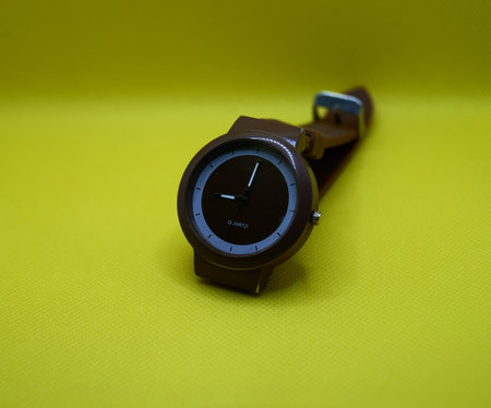 New brown wrist watch on yellow background