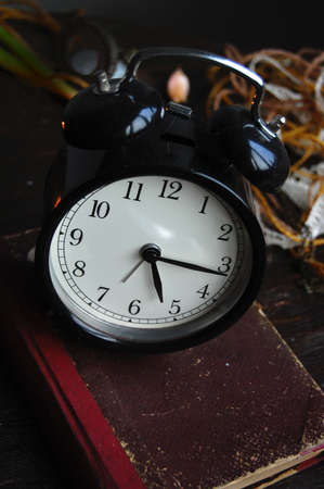 Retro Alarm Clock on an old bookの写真素材