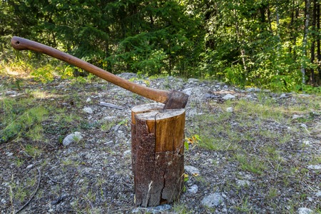 Photo of old blunt axe on logの写真素材
