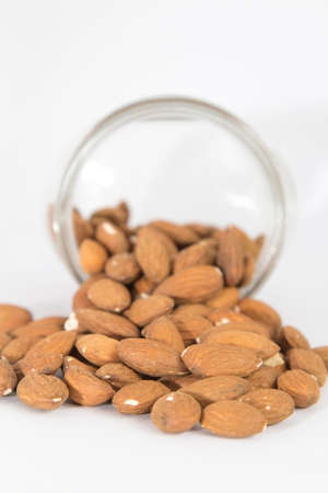 Glass jar and pile of almondsの写真素材